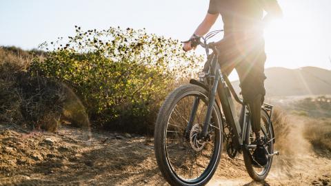 Homme monté sur un vélo électrique qui monte une colline